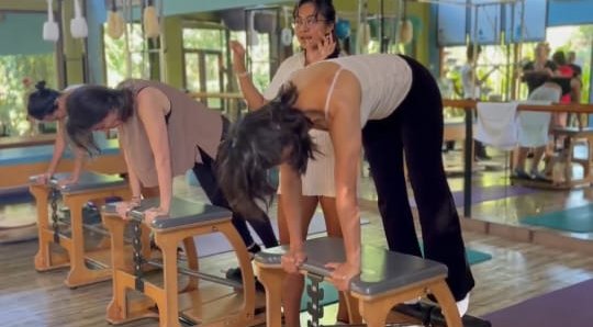 Nana teaching a small group on Pilates chairs
