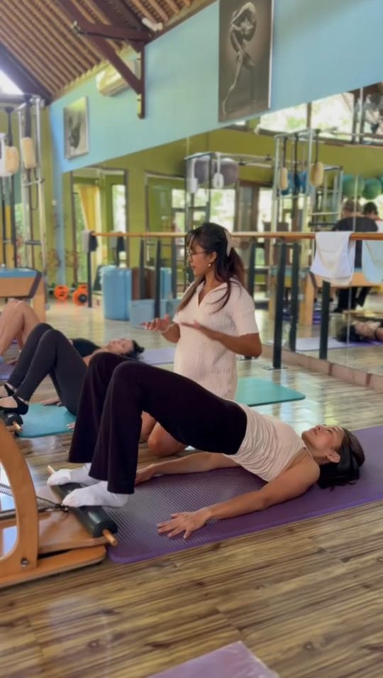 Nana cueing a student through a bridge on the mat